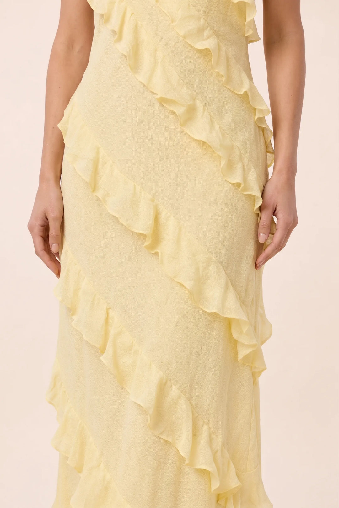 Close-up detail of a yellow tiered ruffle halter maxi dress