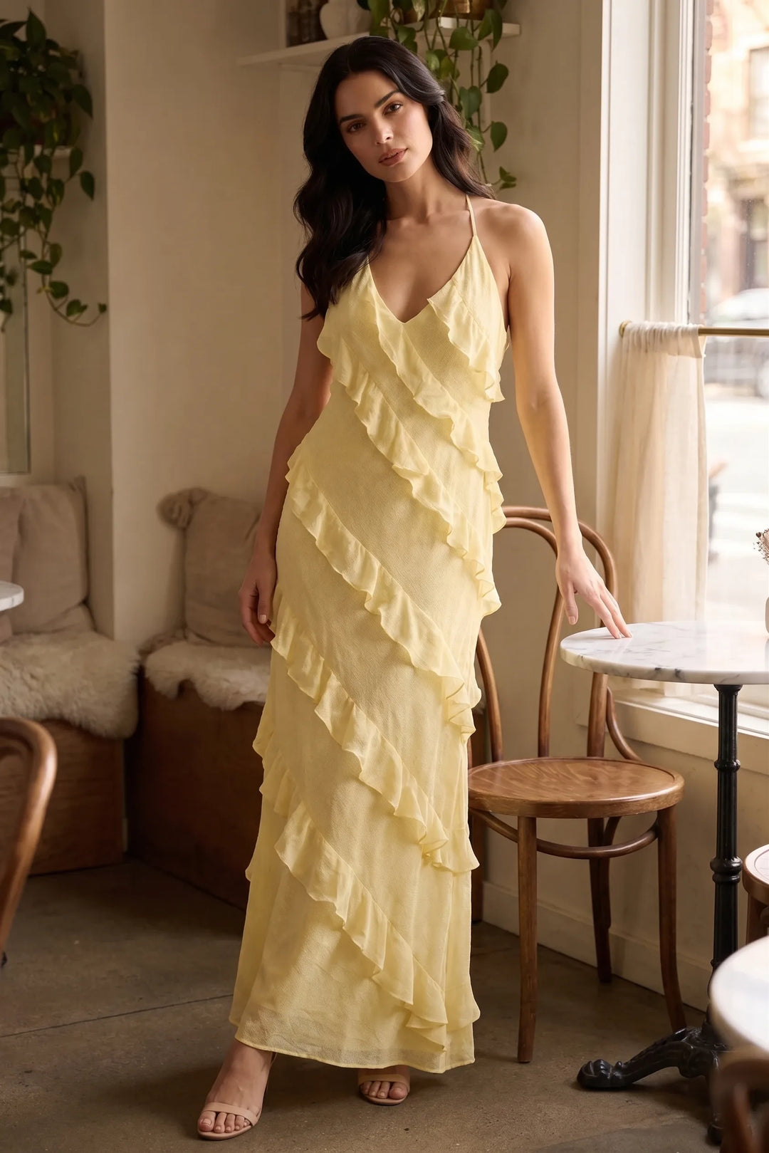 Model wearing a yellow tiered ruffle halter maxi dress in a lifestyle setting