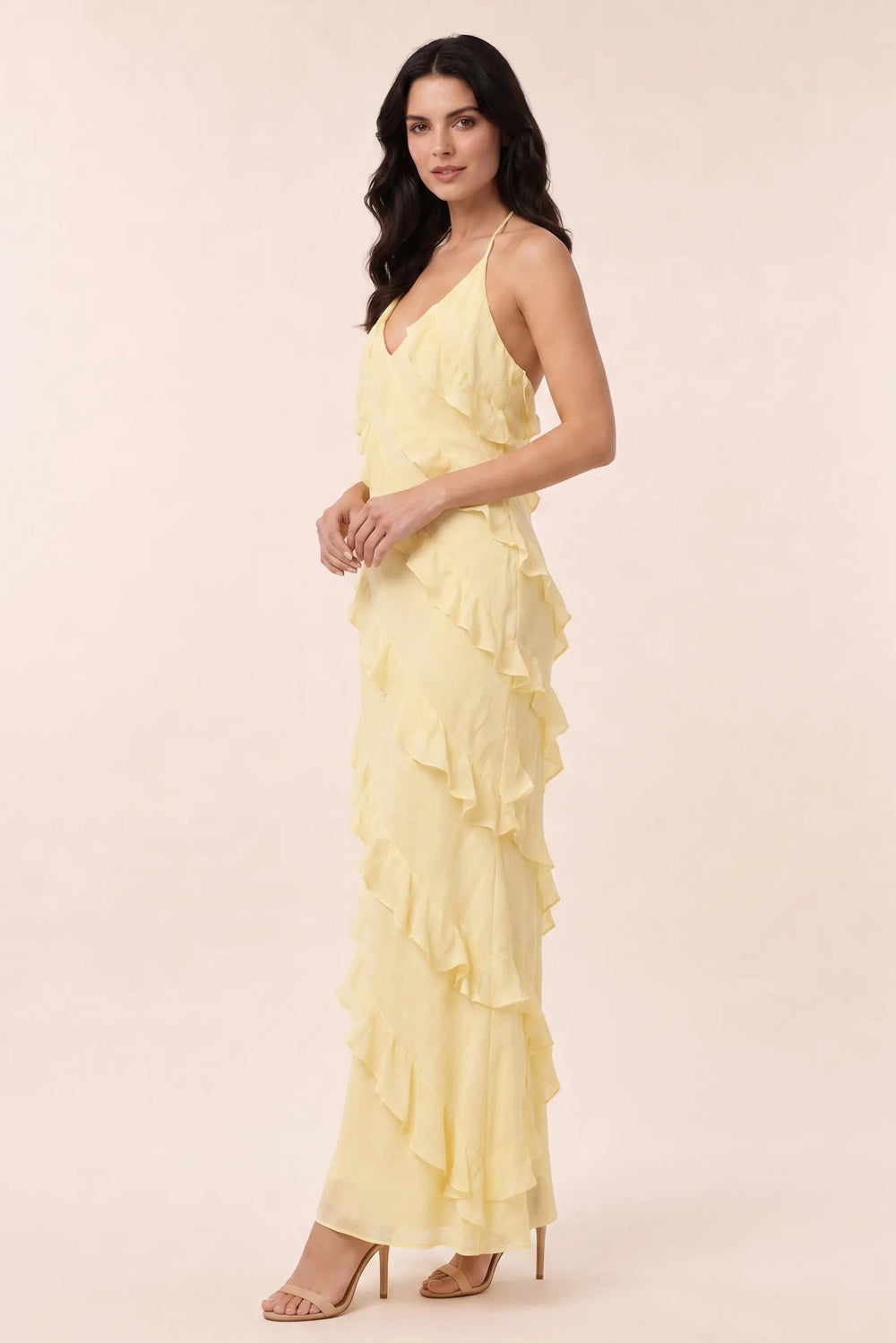 Yellow tiered ruffle halter maxi dress on a model in a three-quarter turn