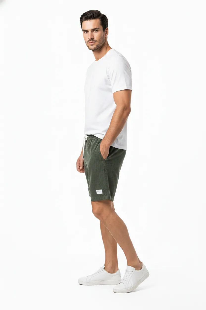 Army green corduroy drawstring shorts on a model in a three-quarter turn