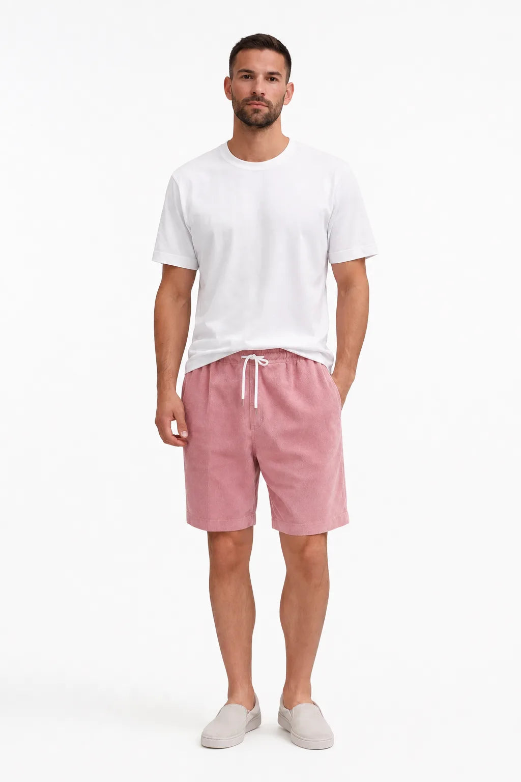 Pink corduroy drawstring shorts on a model in a contrapposto stance