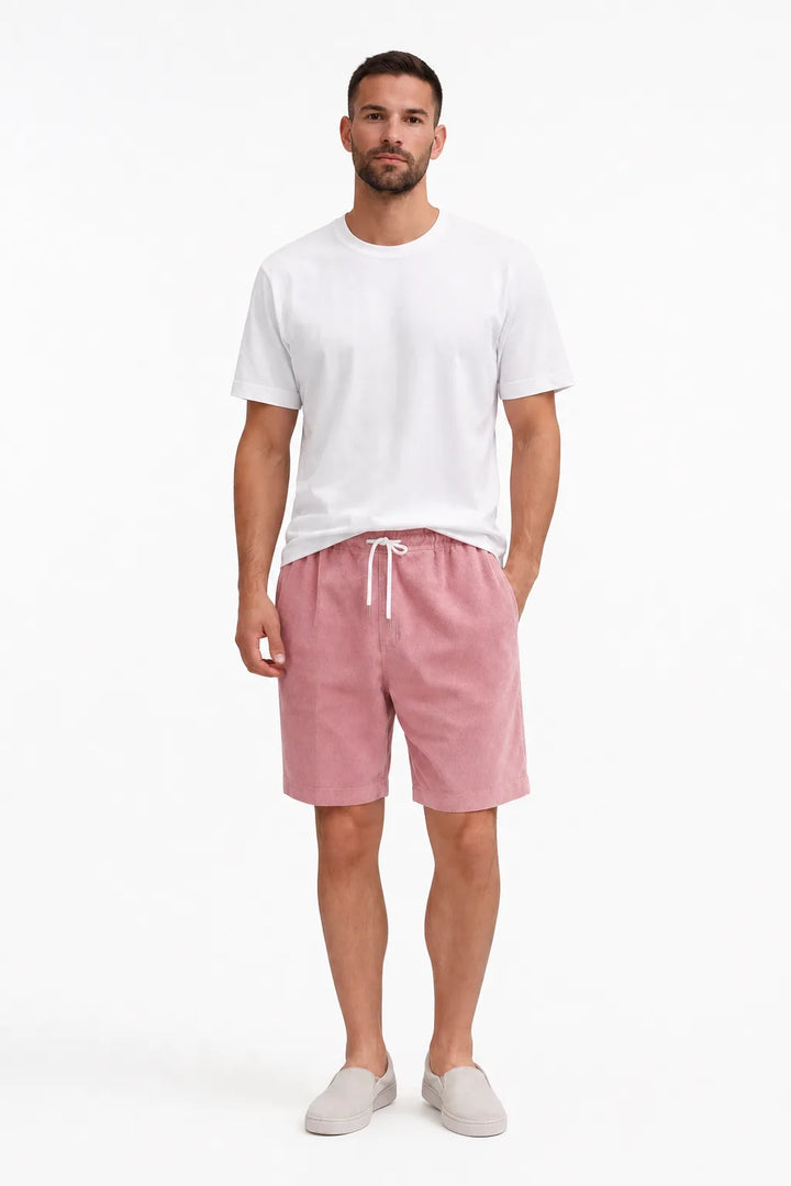 Pink corduroy drawstring shorts on a model in a contrapposto stance