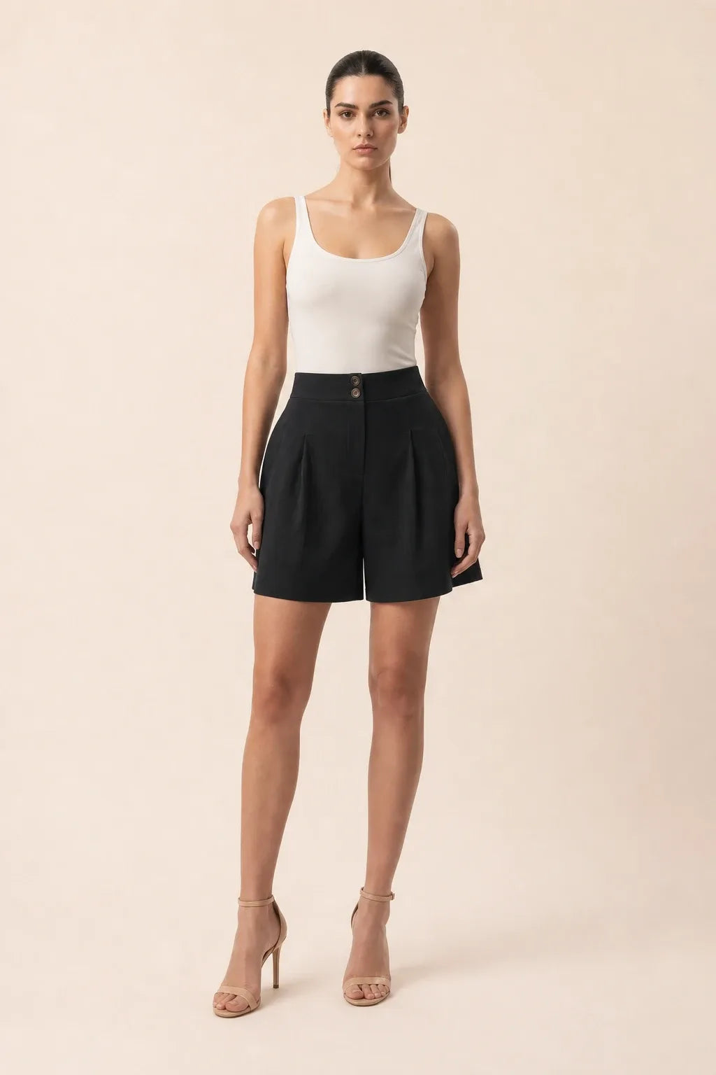 Black pleated Bermuda shorts on a model in a contrapposto stance