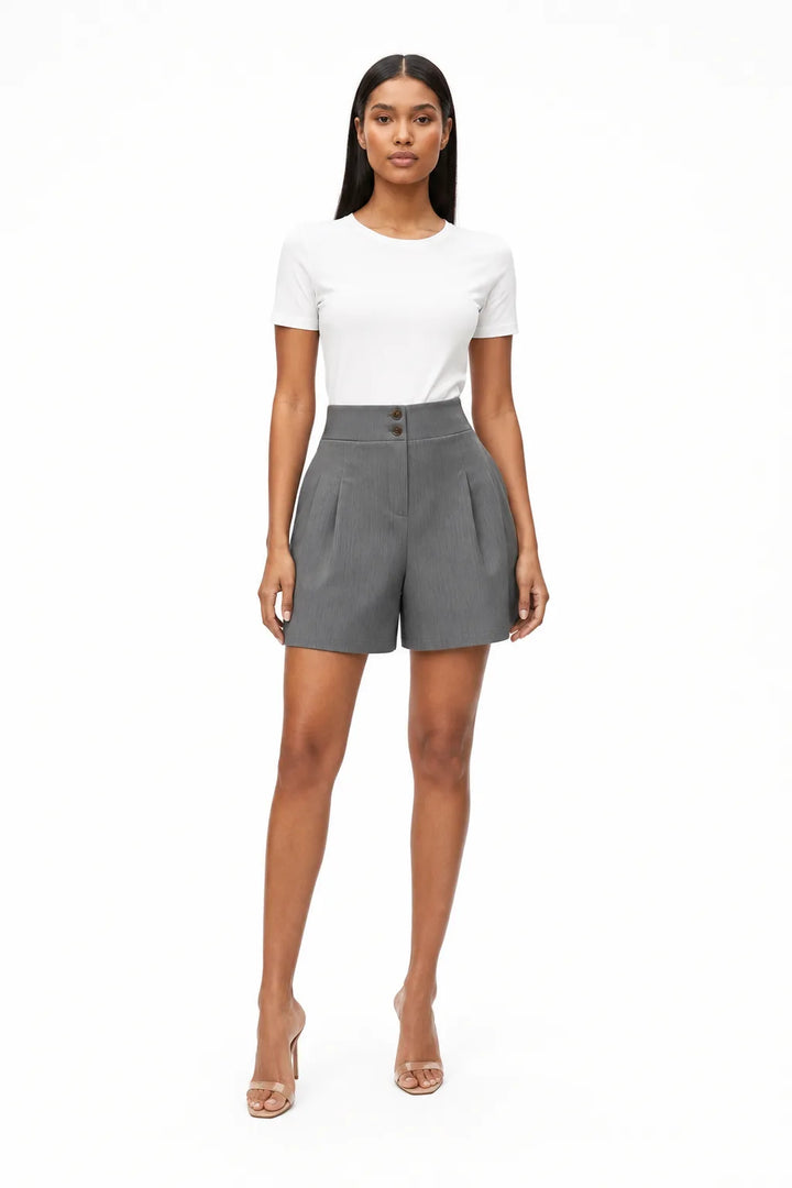 Dark grey pleated Bermuda shorts on a model in a contrapposto stance