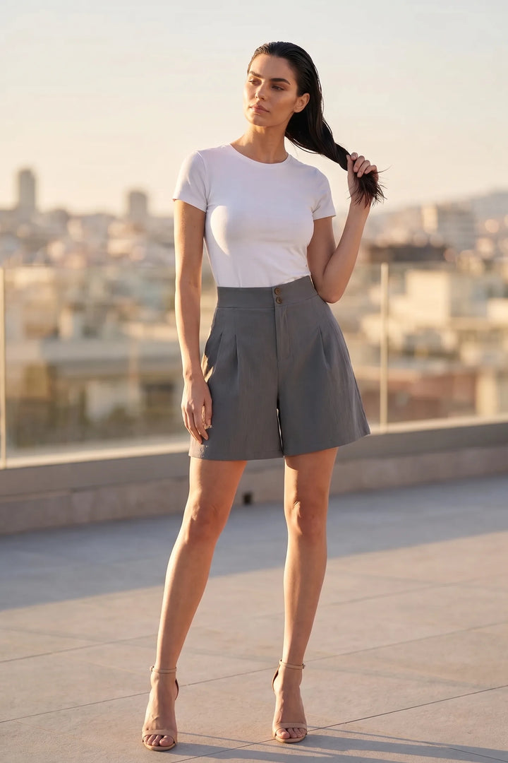 Model wearing dark grey pleated Bermuda shorts in a lifestyle setting