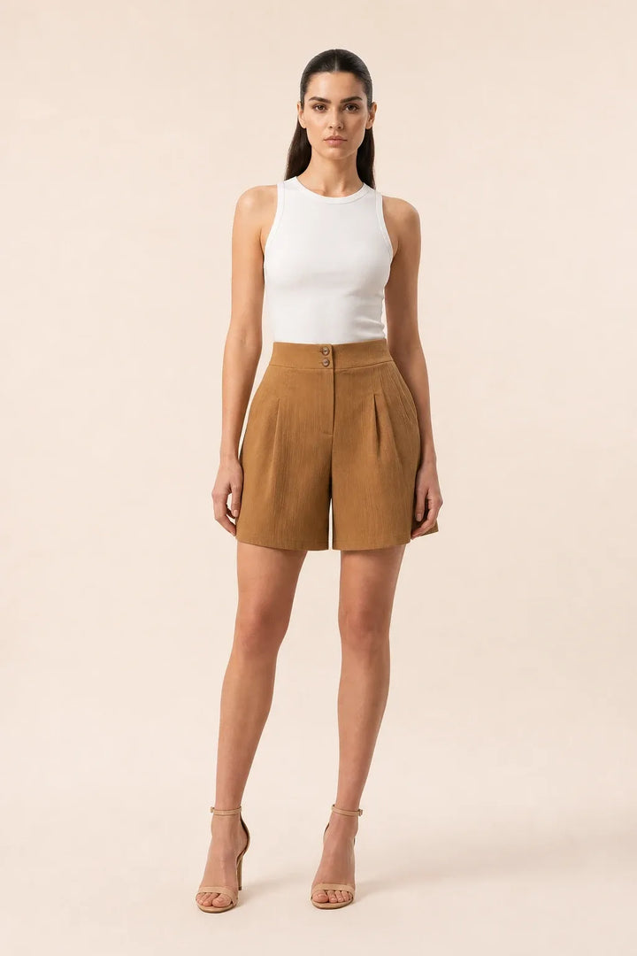Khaki pleated Bermuda shorts on a model in a contrapposto stance