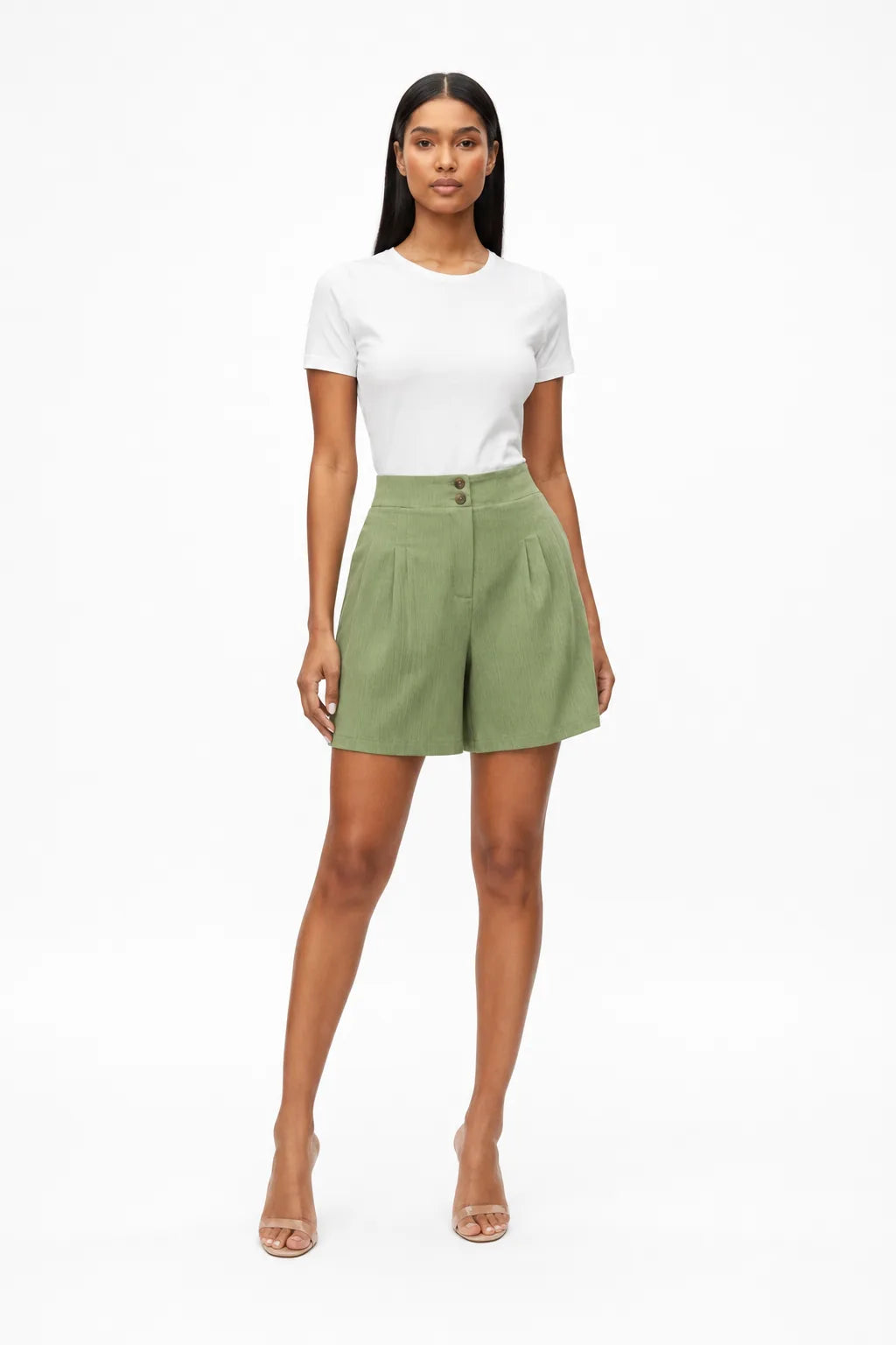 Light green pleated Bermuda shorts on a model in a contrapposto stance