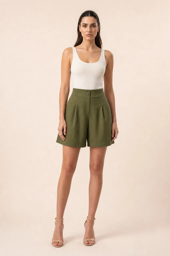 Olive green pleated Bermuda shorts on a model in a contrapposto stance
