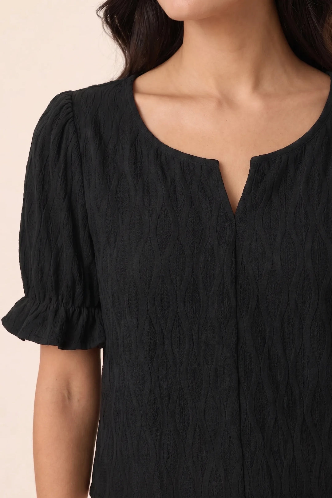 Close-up detail of black puff sleeve blouse showing voluminous gathered sleeve construction