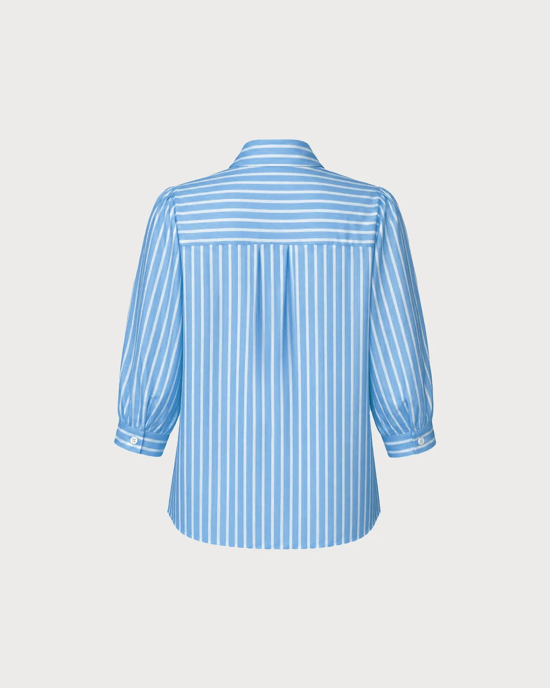 Woman wearing a blue puff sleeve blouse, side profile view
