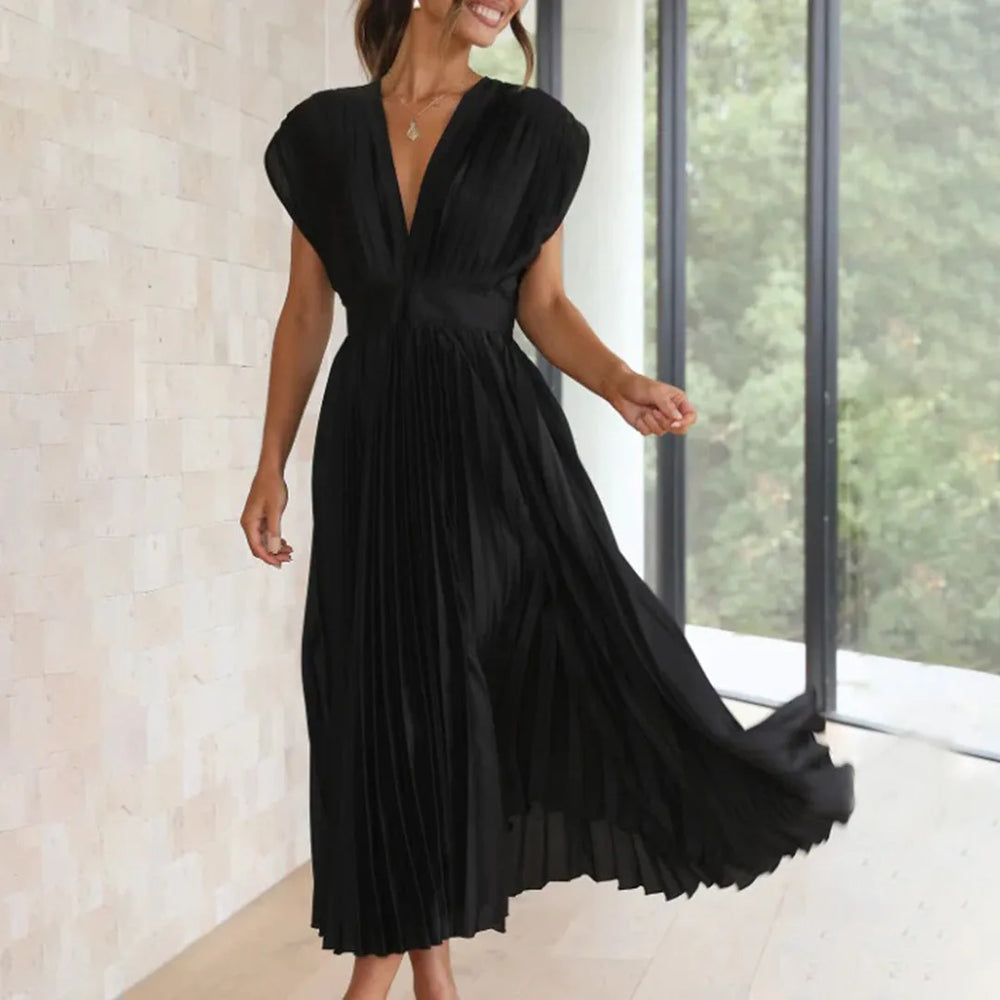 Close-up detail of a black pleated midi dress showing fabric texture and pleating