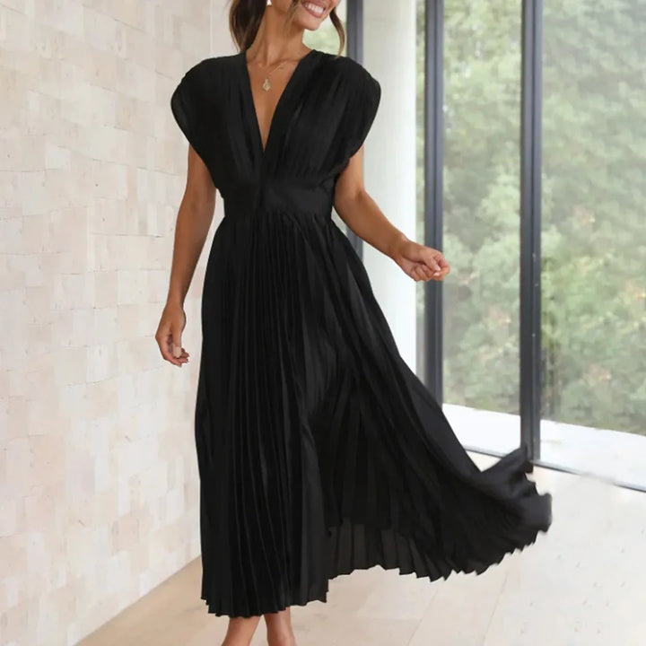 Close-up detail of a black pleated midi dress showing fabric texture and pleating