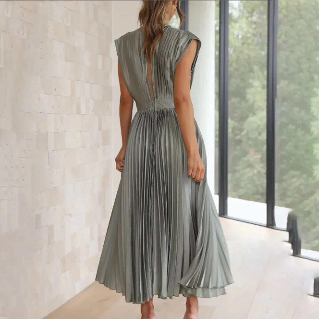 Model in champagne pleated midi dress captured in a dynamic pose