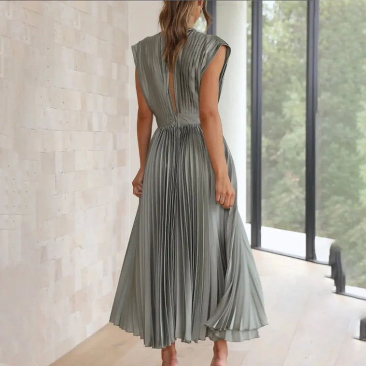 Model in champagne pleated midi dress captured in a dynamic pose