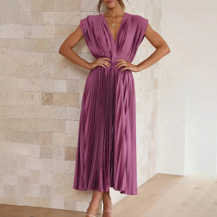 Model wearing champagne pleated midi dress with skirt in motion