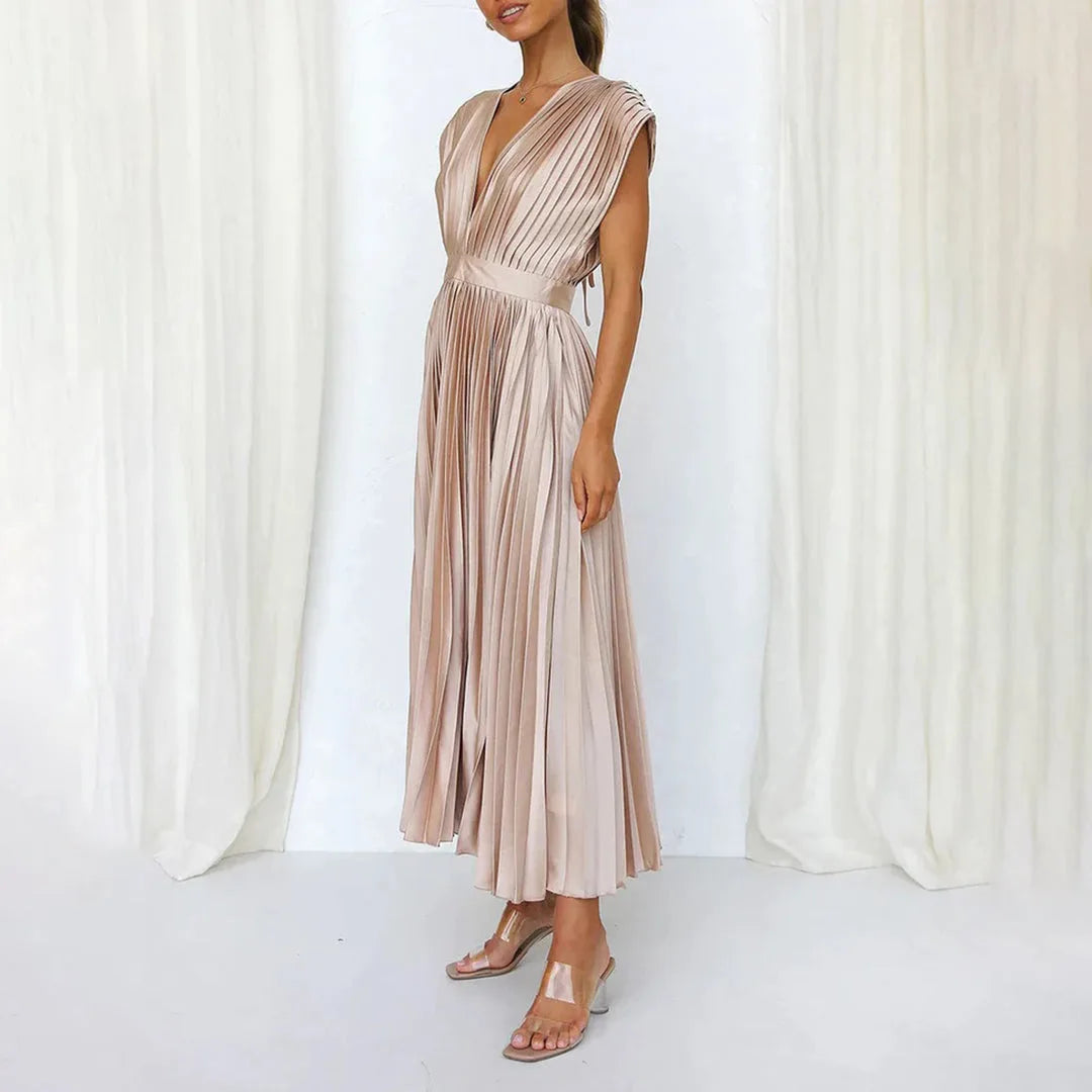 Model in champagne pleated midi dress shown from a low angle