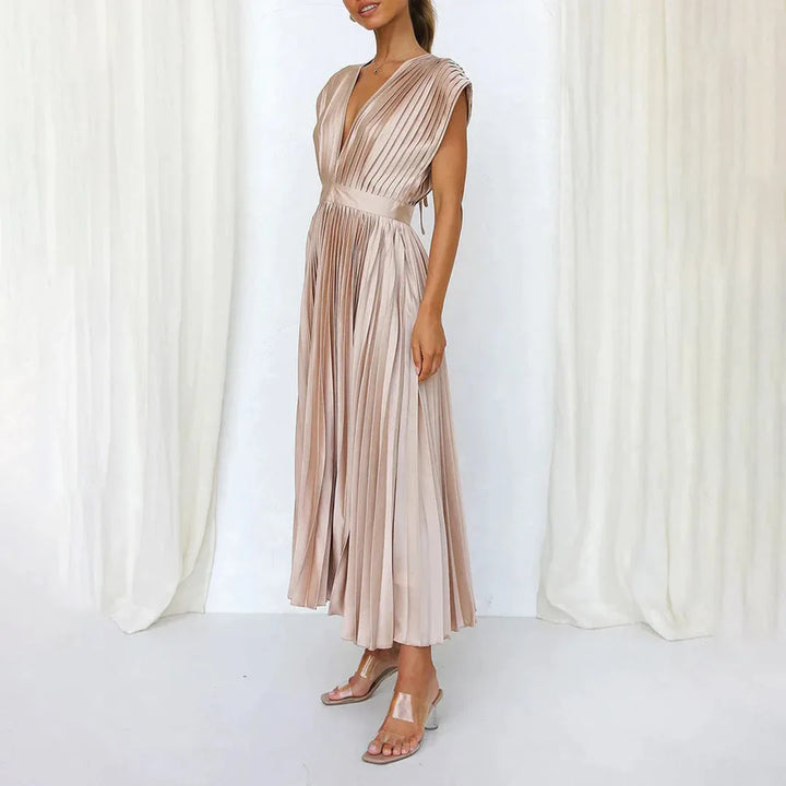 Model in champagne pleated midi dress shown from a low angle