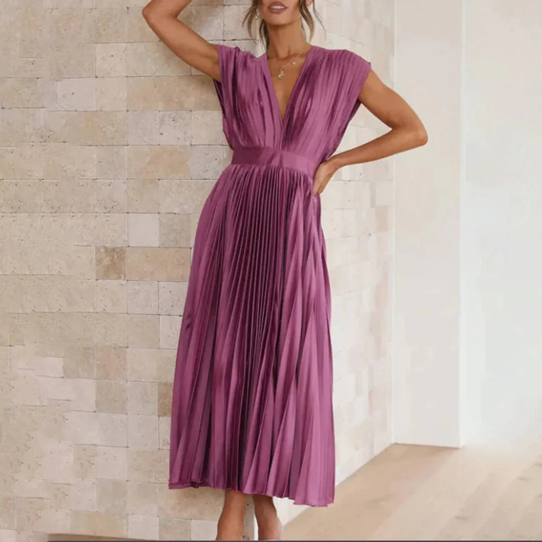 Model in champagne pleated midi dress with focus on pleated hem