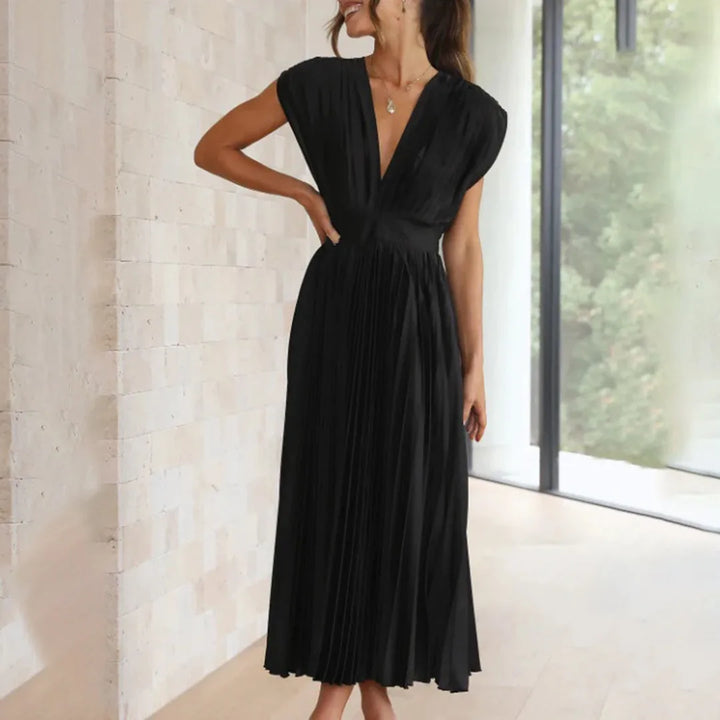 Model in champagne pleated midi dress highlighting waist and drape