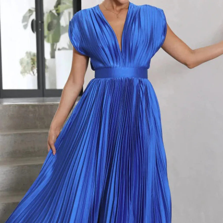 Model wearing champagne pleated midi dress in a soft, relaxed pose