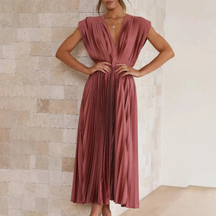 Model in champagne pleated midi dress highlighting fit and silhouette