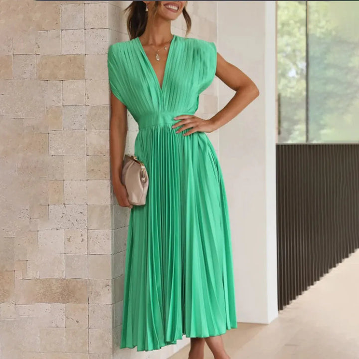 Model wearing a green pleated midi dress with graceful pleated silhouette