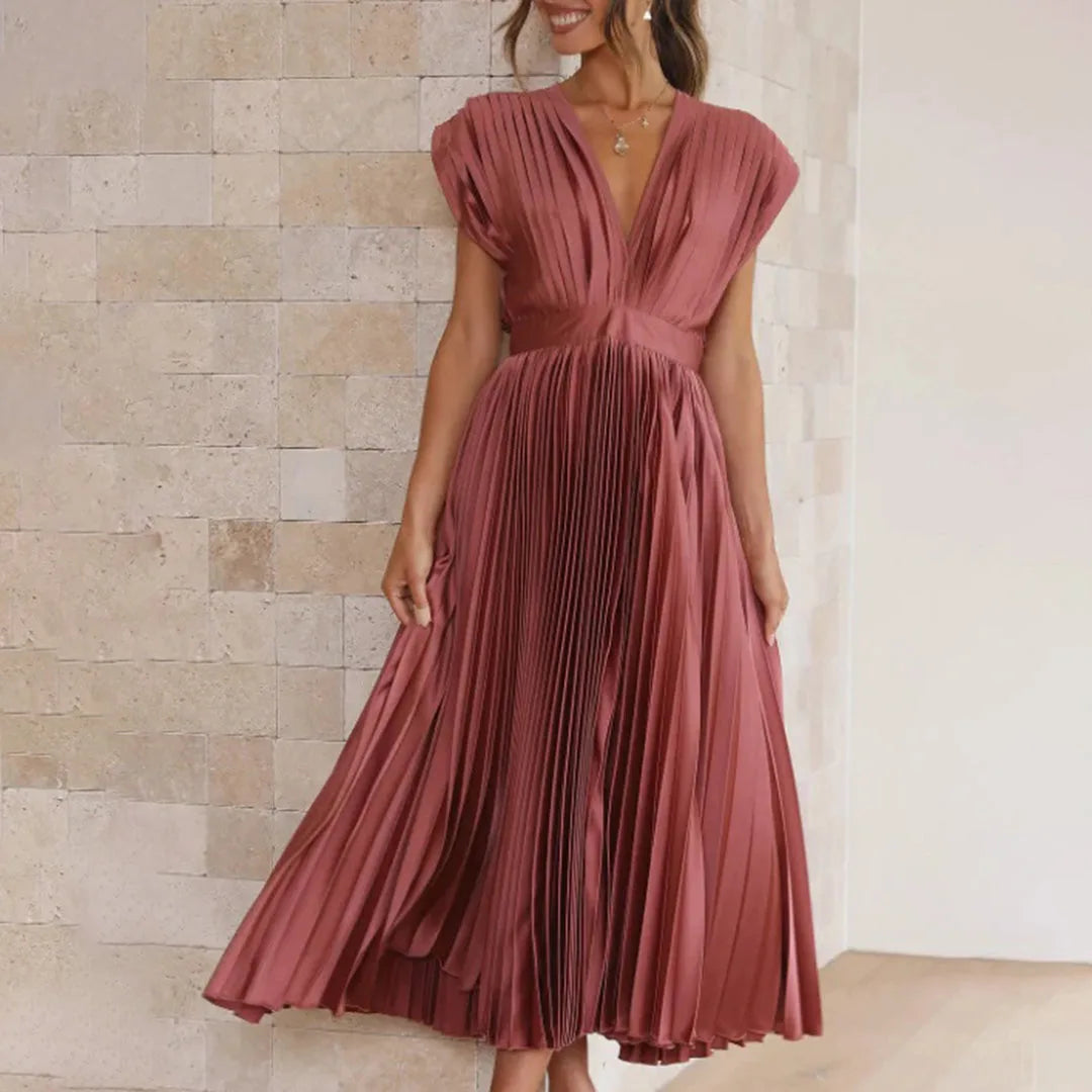 Model in side profile wearing a rose gold pleated midi dress