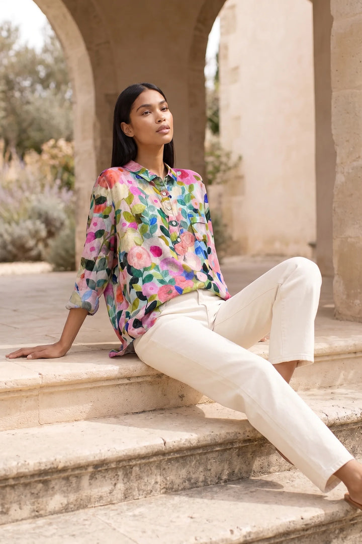 Model wearing a floral print blouse in an outdoor lifestyle setting