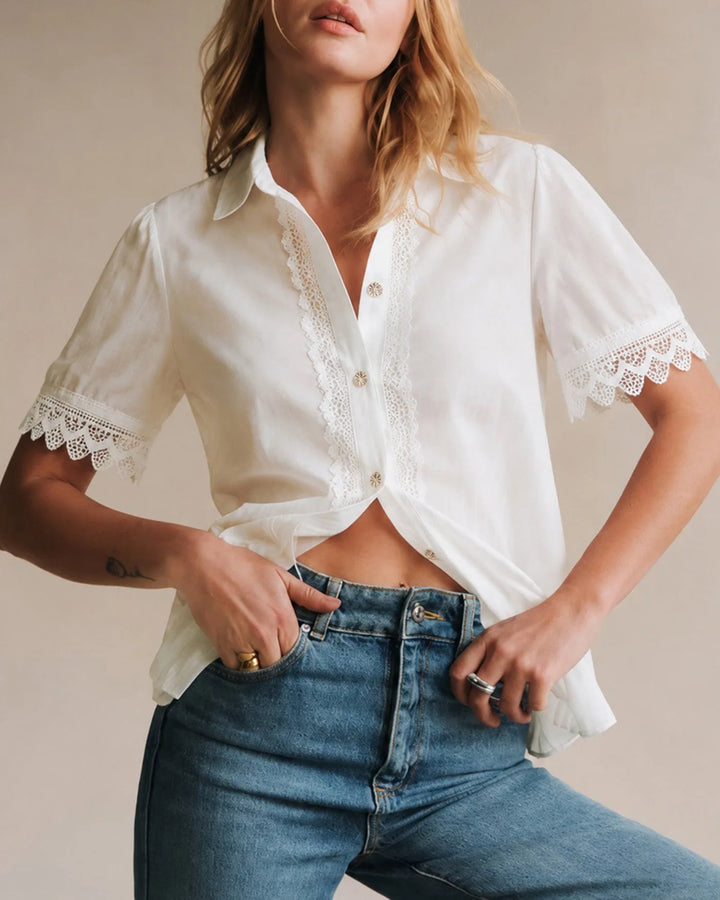Close-up detail of lace trim on white blouse