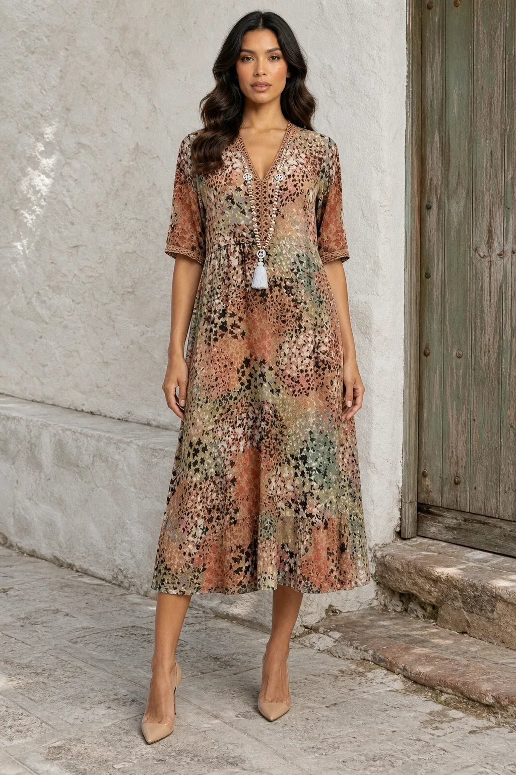 Sandy beige floral boho midi dress on a model in a contrapposto stance