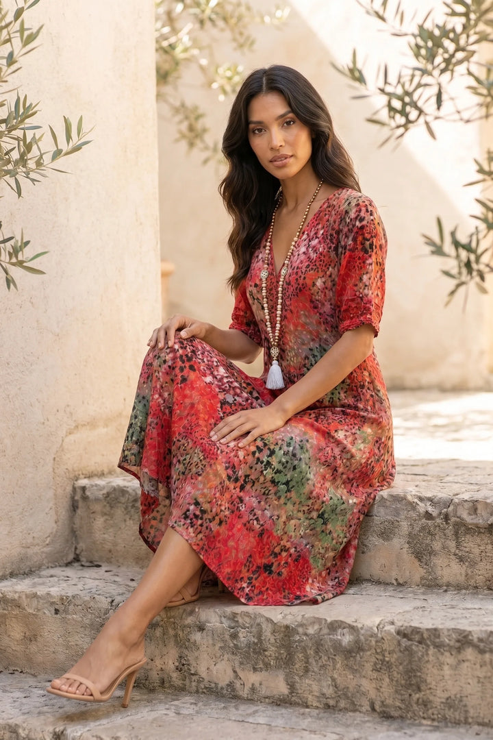 Model wearing a red floral boho midi dress in an outdoor lifestyle setting