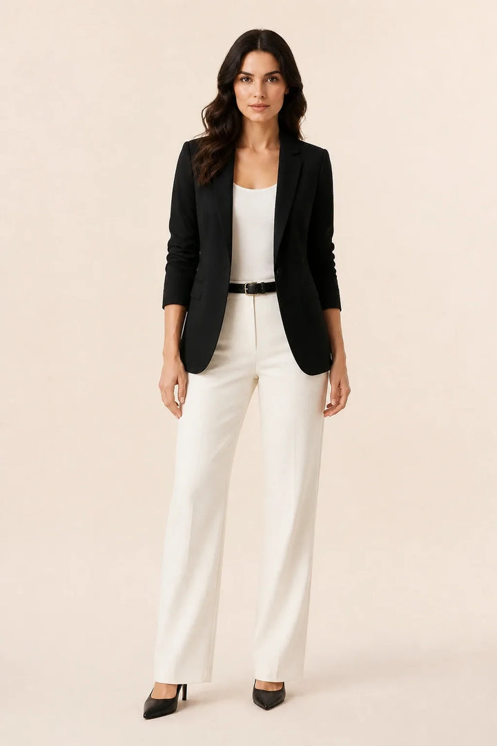 Black open-front blazer with notch lapels worn by a model in a contrapposto stance
