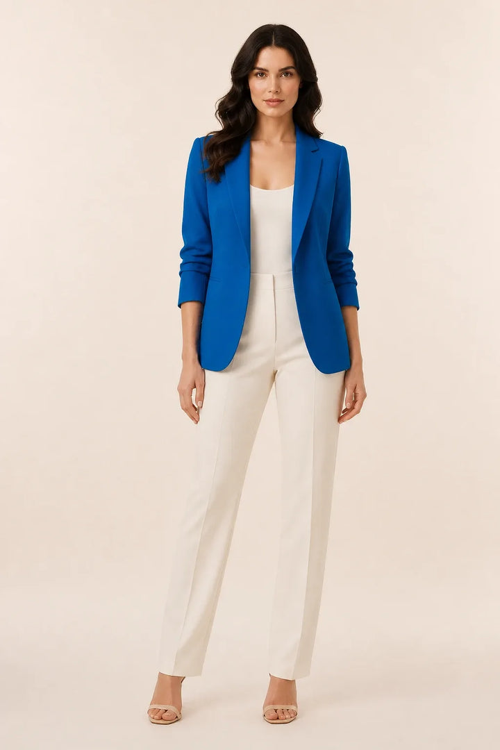Blue open-front blazer with notch lapels worn by a model in a contrapposto stance