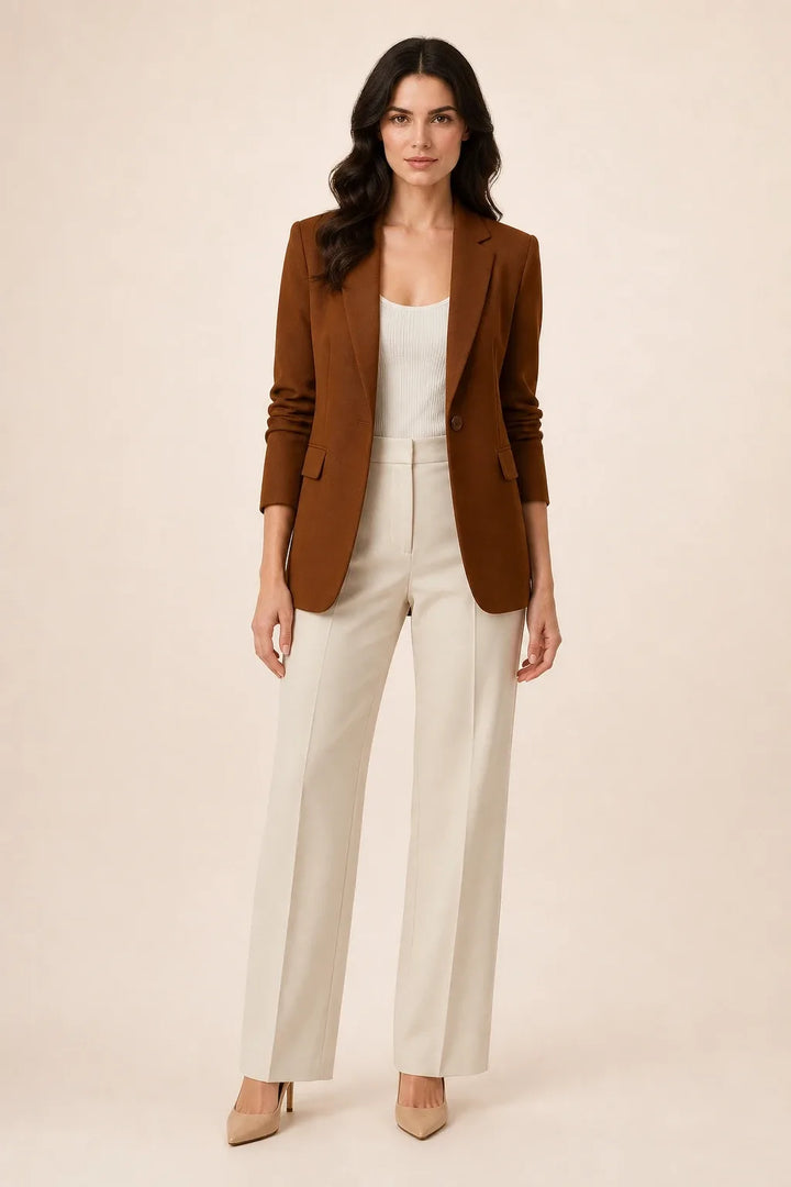 Brown open-front blazer with notch lapels worn by a model in a contrapposto stance