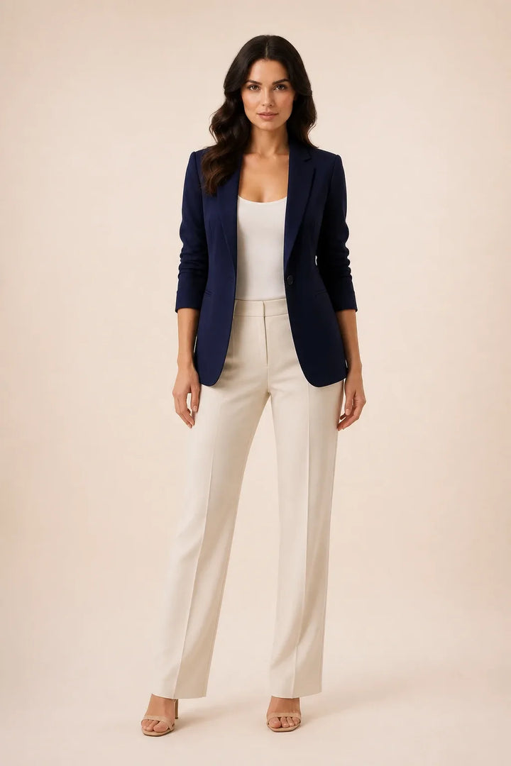 Dark blue open-front blazer with notch lapels worn by a model in a contrapposto stance