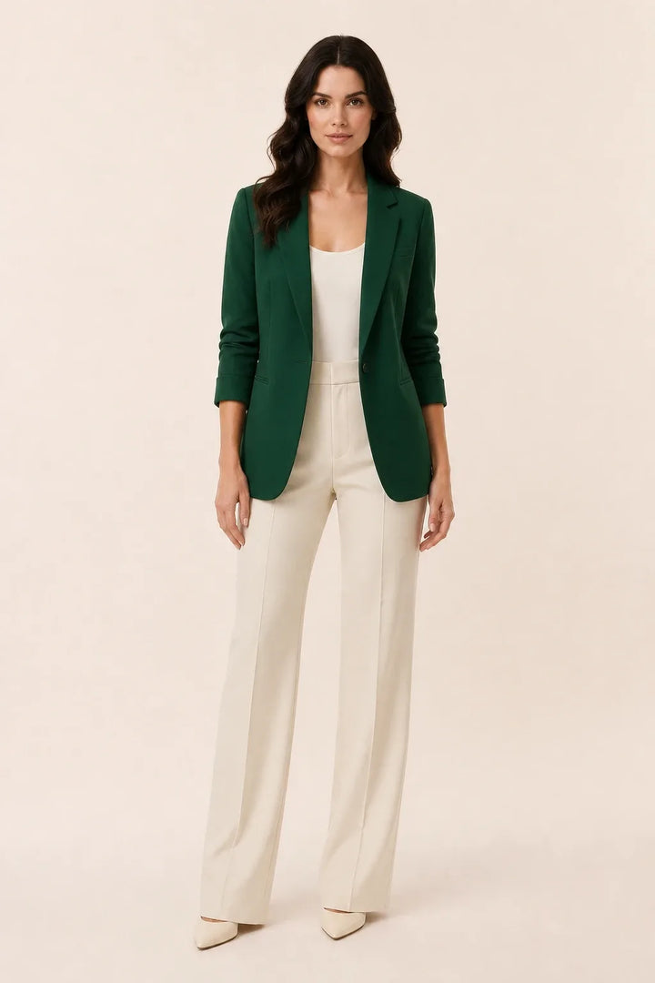 Green open-front blazer with notch lapels worn by a model in a contrapposto stance