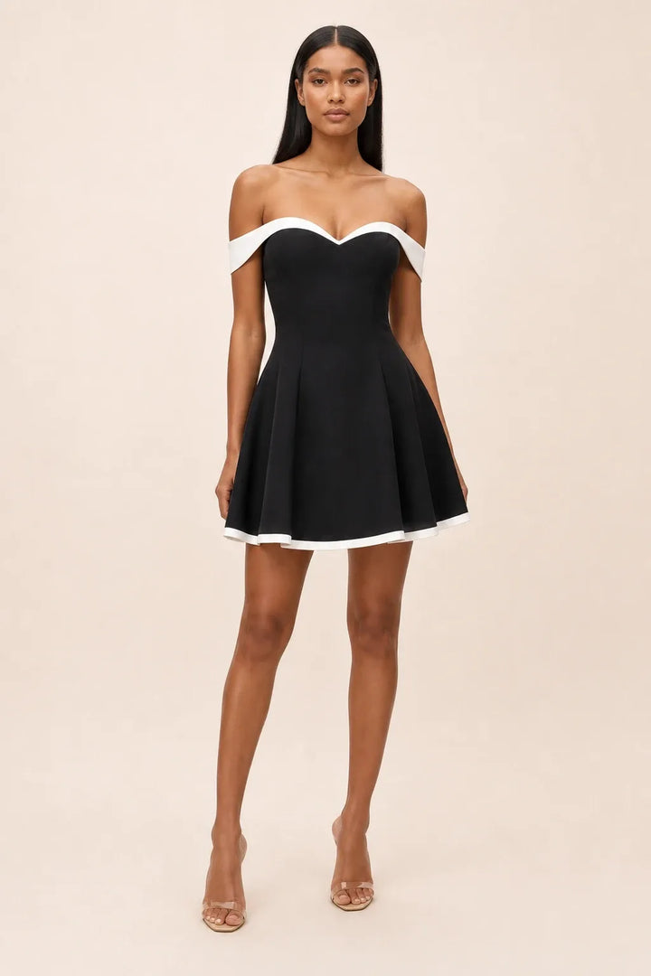 Black and white off-shoulder skater mini dress on model in contrapposto stance