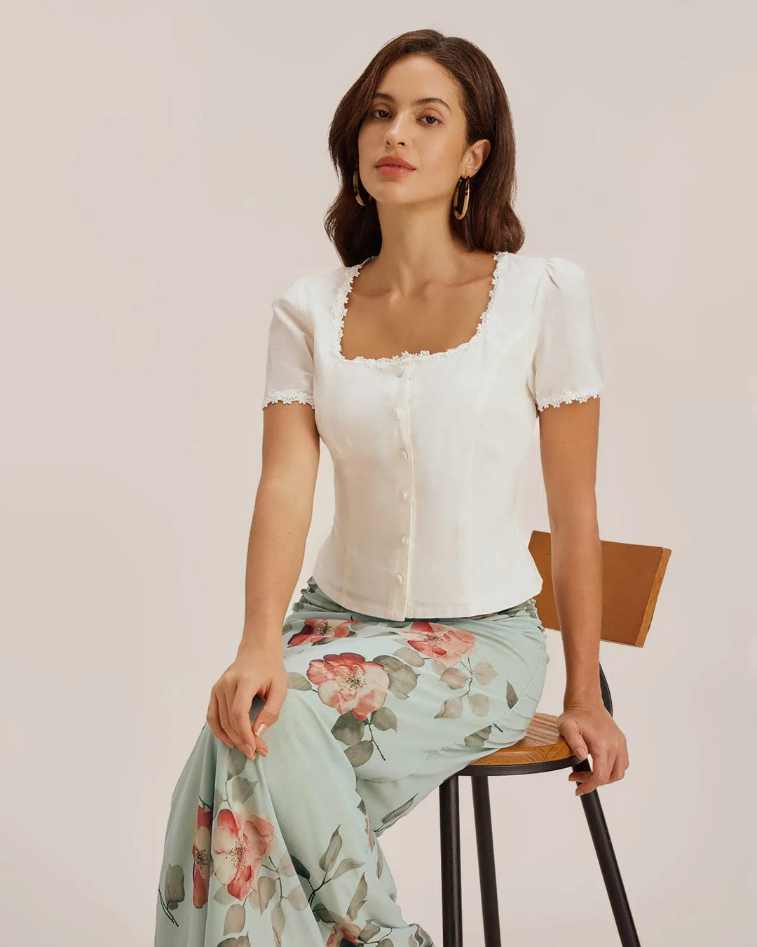 Close-up detail of lace trim and button placket on white blouse