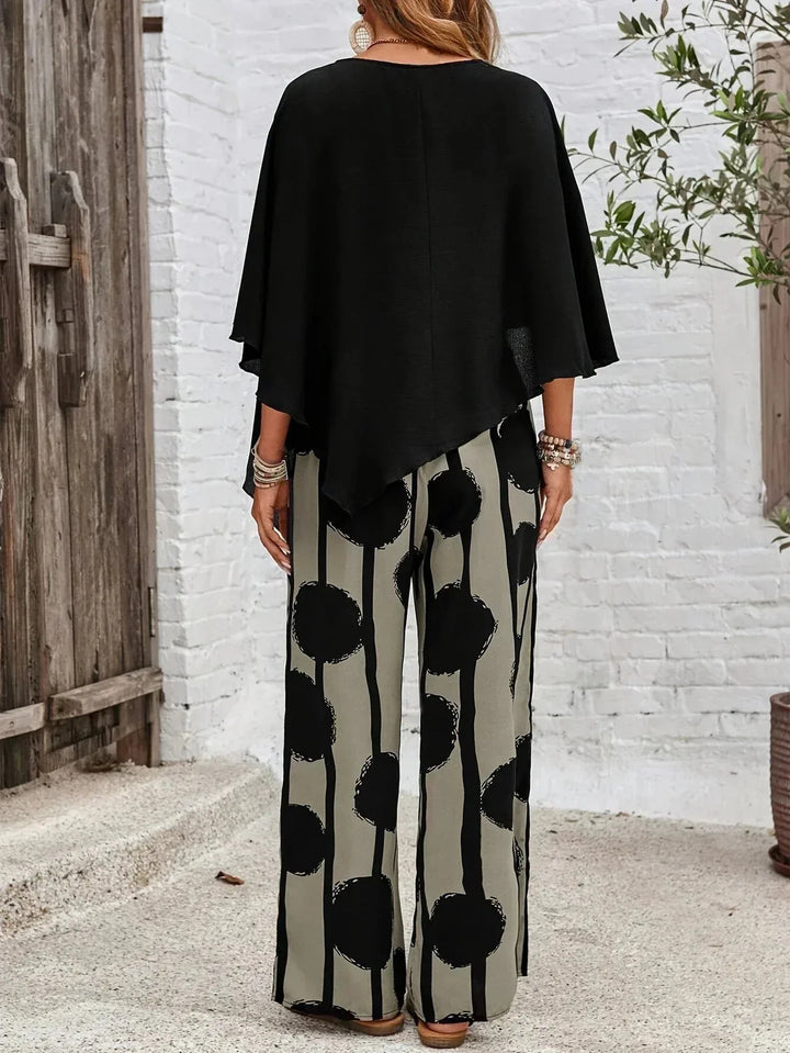 Black batwing sleeve top and wide-leg trousers on model from the side