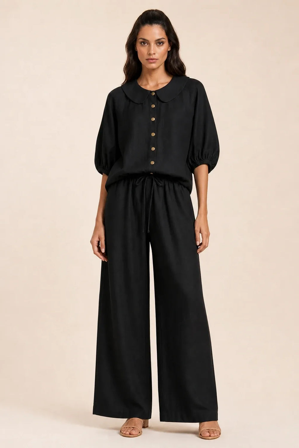 Black peter pan collar top and matching shorts set on model in contrapposto stance