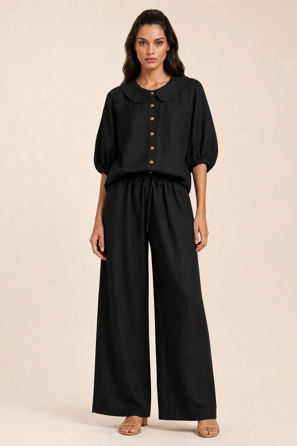 Black peter pan collar top and matching shorts set on model in contrapposto stance