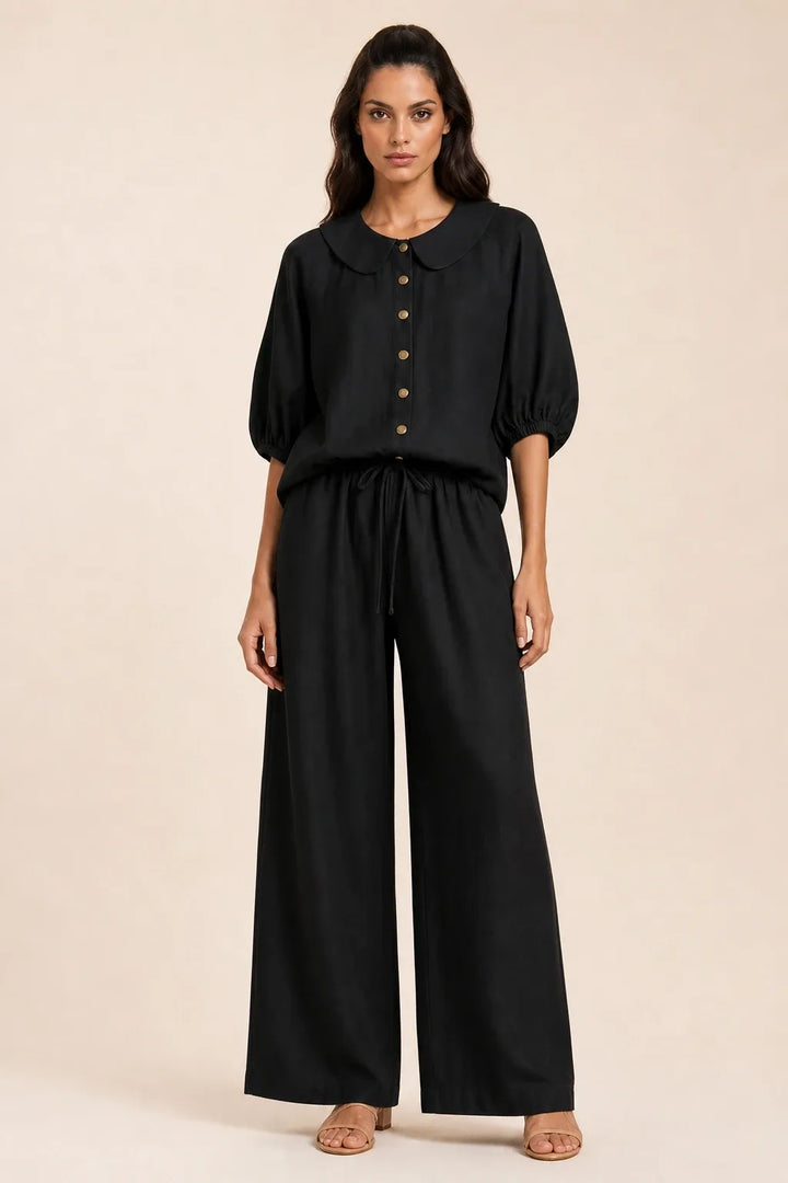 Black peter pan collar top and matching shorts set on model in contrapposto stance