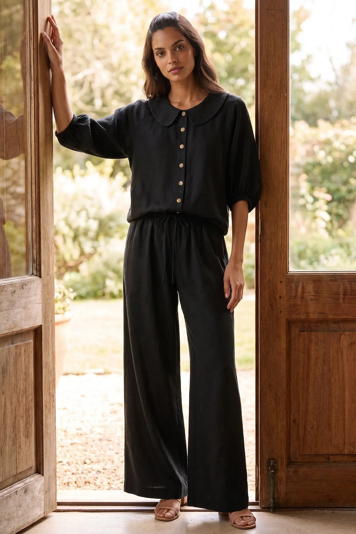 Model wearing black peter pan collar top and shorts set in lifestyle setting