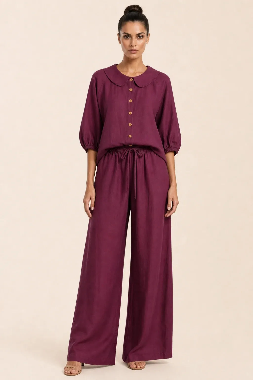 Burgundy peter pan collar top and matching shorts set on model in contrapposto stance
