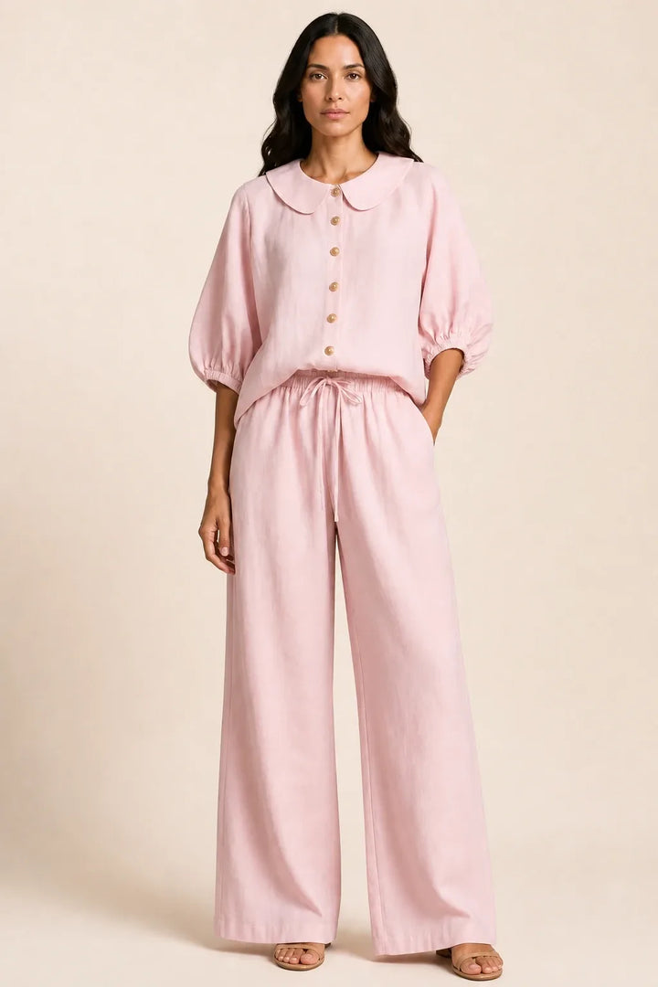 Pink peter pan collar top and matching shorts set on model in contrapposto stance