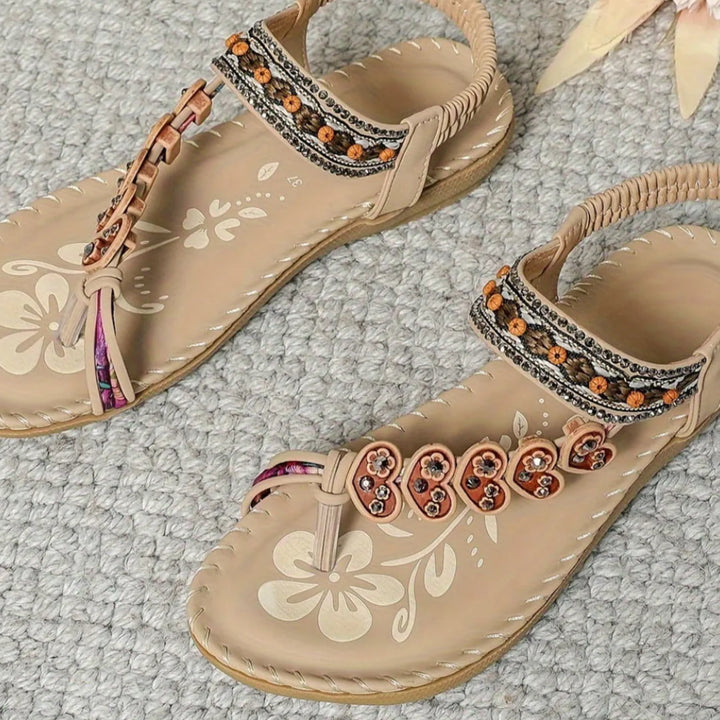 Beige flat sandal with boho embellishments, front view