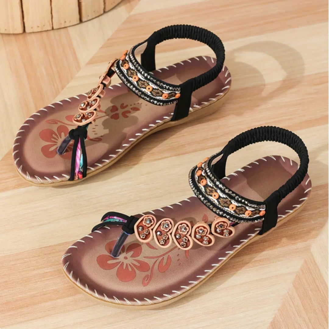 Black flat sandal with boho embellishments, front view