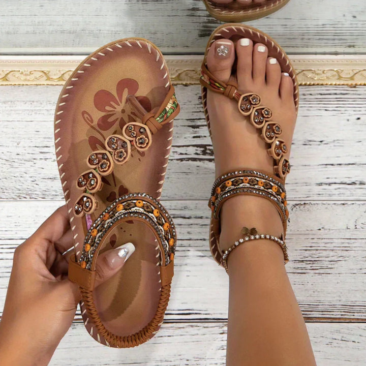 Brown flat sandal with boho embellishments, front view