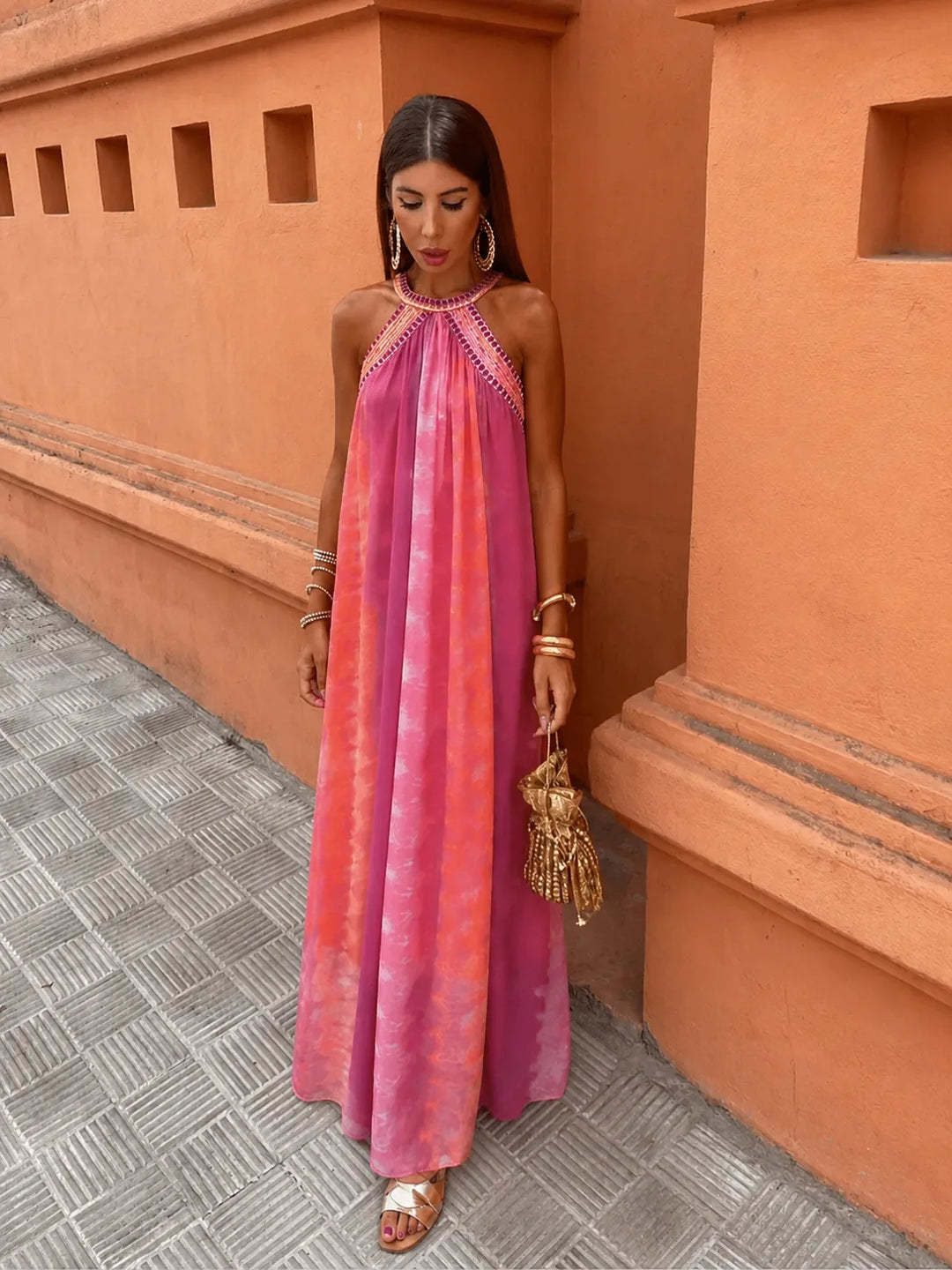 Woman wearing a multicolor embroidered halter maxi dress, alternate angle