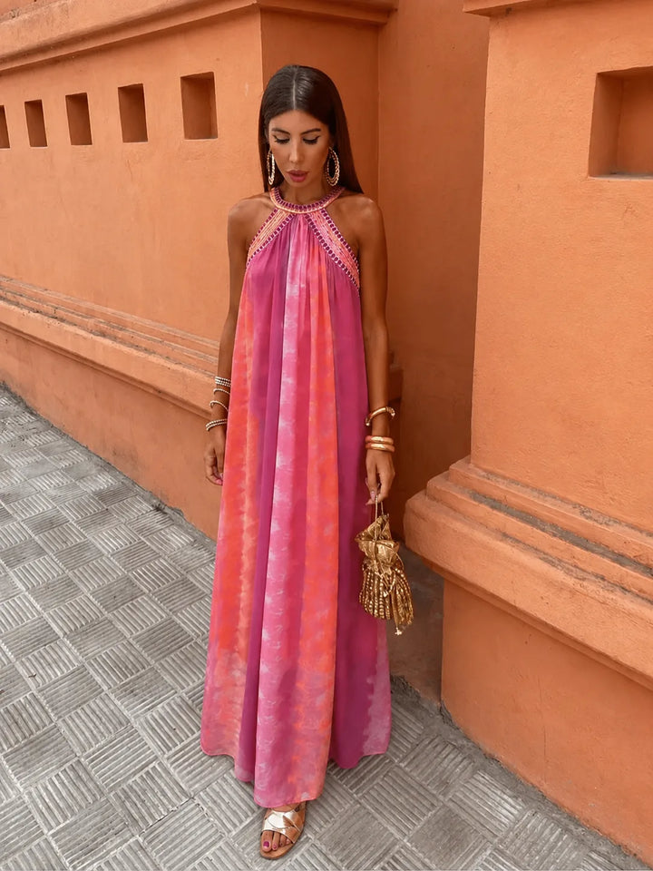 Woman wearing a multicolor embroidered halter maxi dress, alternate angle